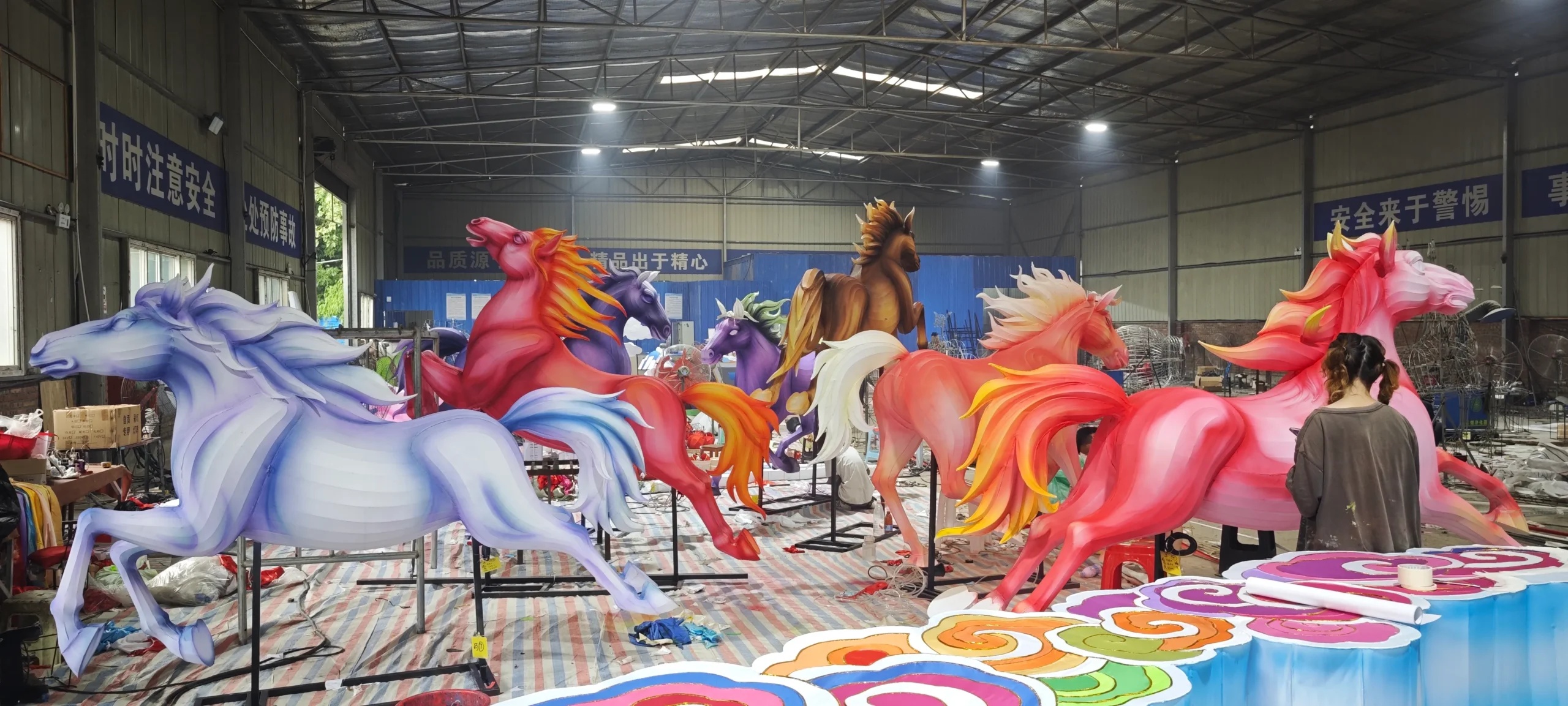 Several finished coloured horse figures in a workshop.